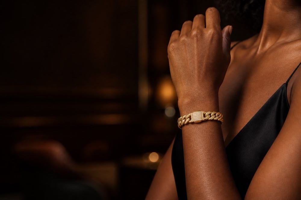 Gold Cuban-link bracelet worn in an evening setting